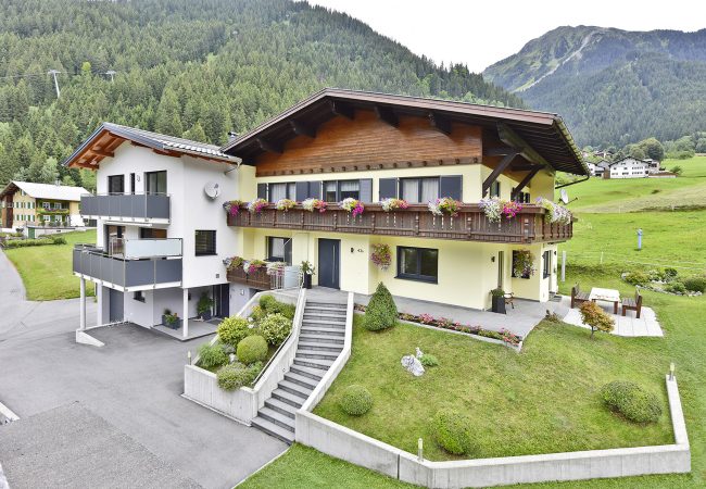 Außenaufnahme des Haus Schallner mit Blick auf Garten und Bergen im Hintergrund