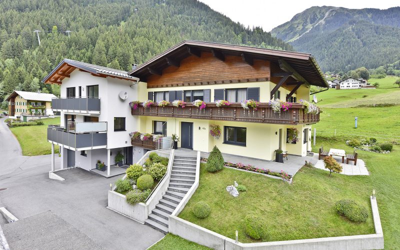 Außenaufnahme des Haus Schallner mit Blick auf Garten und Bergen im Hintergrund